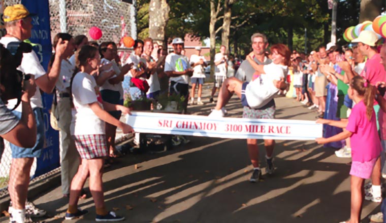 Ed Kelly carries his wife across the finish line of the 1999 race