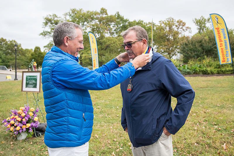 Coach Jim Hurt, Head Track Coach at St. John's University, receives the Peace Run Torch-Bearer award