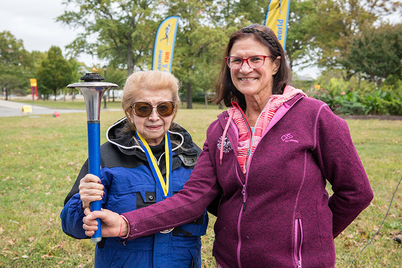 Ms. Najibe Burger holds the Peace Torch with her good friend, Pranika Baum